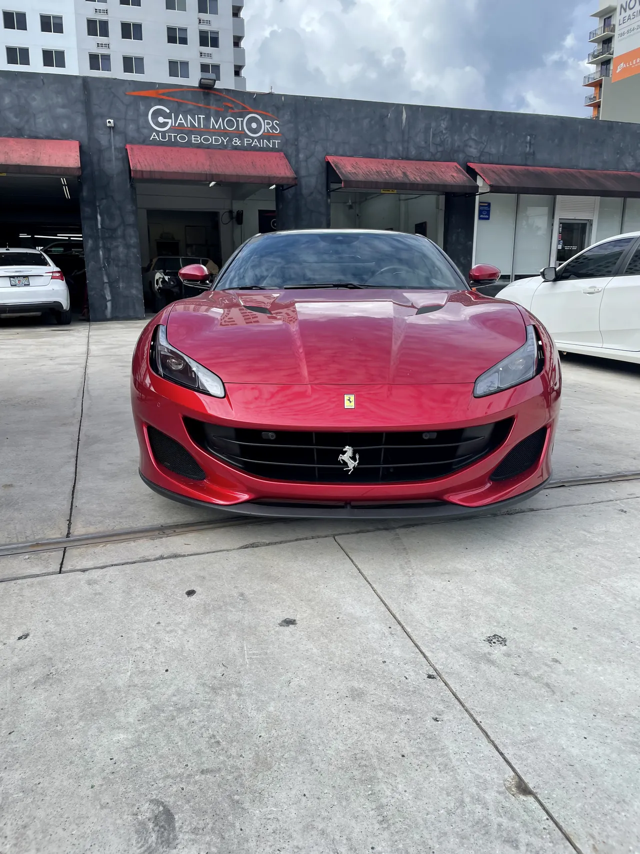 A red Ferrari Portofino outside Giant Motors Auto Body & Paint